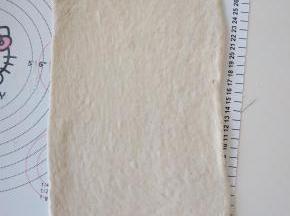 7、取面团擀开，翻面后擀成长方形，压薄底边。
