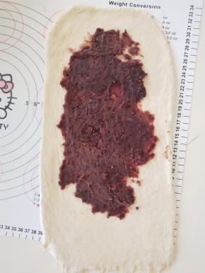 8、取一半豆沙涂抹在面饼上，四周留白。
