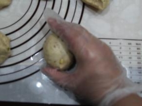 右手如图握住一个面团，反C空心掌，握住逆时针滚圆。揉圆8个面团。