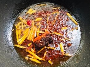 锅烧热放入适量的油，放入生姜，郫县豆瓣酱和火锅底料小火爆香。