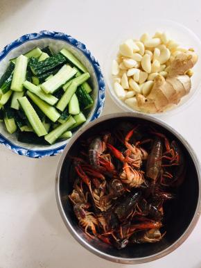 黄瓜洗净切成条，蒜瓣剥皮，生姜一块清洗干净，小龙虾剪去头上的虾包，抽掉虾线，虾背上剪开，用牙刷把处理好的小龙虾刷洗干净备用。