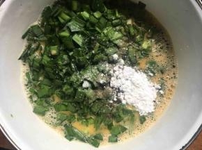 将韭菜倒入蛋液中，再倒入适量食盐、胡椒粉、淀粉；