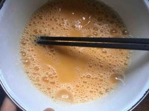 鸡蛋磕入碗中，用筷子搅散备用；