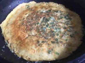 一面煎黄后，沿着锅边倒入少许油，润滑蛋饼与锅后，翻面继续煎，两面金黄即可出锅；