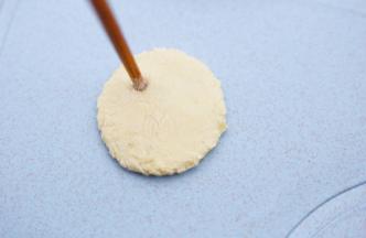 用一根圆筷子的底部在圆面片上戳出两只眼晴。