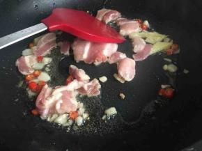 爆香后放入五花肉，倒入少许料酒继续翻炒；