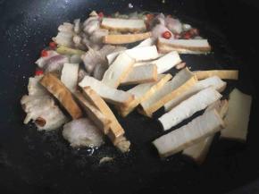 五花肉稍微出油，倒入香干继续中火煎制；