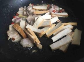 五花肉稍微出油，倒入香干继续中火煎制；