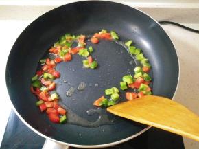 热锅放入凉油，放入青红辣椒翻炒。