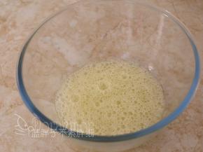 电动打蛋器低速将蛋白搅打至起鱼眼泡，加入1/3的糖粉。