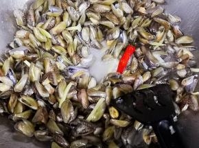 倒入海瓜子继续翻炒，加入适量的盐，酱油