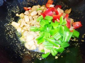 鸡肉炒至变色放青红椒。