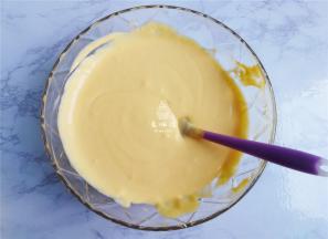 把芒果泥倒入打发好的奶油中，混合均匀。