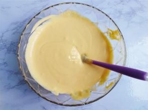 把芒果泥倒入打发好的奶油中，混合均匀。