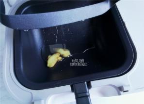 启动机器热锅，倒入食用油和姜片，炒出香味。