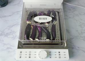 首先把茄子去掉蒂头洗净，切半入电蒸锅上。