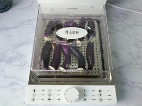 首先把茄子去掉蒂头洗净，切半入电蒸锅上。