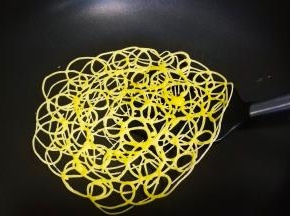 蛋糊凝固后用铲子从边上铲起一边