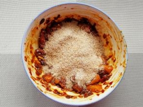 接着倒入蒸米粉，每一块肉都要裹上米粉备用。