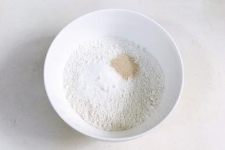 往面粉中加入糖粉和酵母粉。