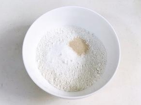 往面粉中加入糖粉和酵母粉。