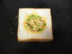 将吐司片翻另一面，继续煎至定形