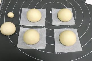 把面团先分出5克（表情）和35克（粽叶），其余的均分成4个约50克（粽子包）的小面团，依次滚圆。