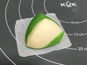 把粽叶从前面往底面绕到顶部上，接着继续往下面。