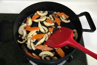 加入胡萝卜约炒1分钟变色，接着倒入蘑菇片炒软。