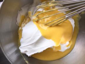 取1/3打发好的蛋白，与蛋黄糊翻拌混合均匀