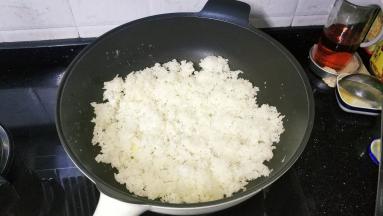 锅里热油放入3碗剩米饭翻炒均匀