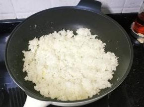 锅里热油放入3碗剩米饭翻炒均匀