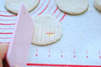 把小剂子按扁，擀成圆片，用刮板从面皮一半的地方压出竖纹。面片要薄厚均匀，不能像饺子皮、包子皮一样四周薄中间厚。压痕稍微重一点，但不要压透，也不要太密集，否则花纹不明显。