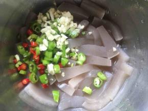 沥干水份倒入大蒜、辣椒、香葱；