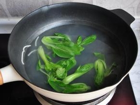 将洗好的油菜对切，放在煮面的锅中略烫一下即可。面汤有余温，因为菜嫩，所以略烫即可。您也可以在煮面关火时放进去一起焖一下。我喜欢青菜爽脆的口感，所以是后放的