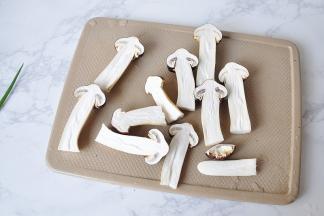 松茸洗净后去根，竖起对切开，对切就行，不要切得太薄，我试着将松茸分成了四份，结果把顶部的菌盖给切掉了，得不偿失，而且下一步煎制时，太薄也不好看，吃起来口感过干。