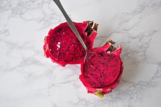 火龙果对切开，然后用刀划几下，这样就中以轻松的用勺子完整的挖出，而且汤汁还不易流出。如果可以把火龙果和香蕉提前放在冰箱中稍微冷冻一下，口感会更佳。