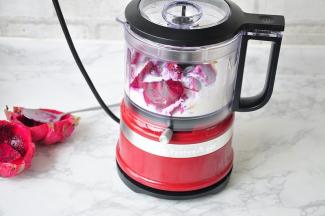 将切好的火龙果、香蕉放进KitcherAid食物料理机中加入酸奶。您也可以使用其它能将食材搅打到至细腻的机器 。火龙果我用的是小个头的，一个只有二百多克，所以我把它全部放进去了。