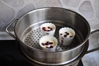 还有点蛋糊，我放在蒸锅中，上面撒了蔓越莓，也蒸30分钟。蒸的过程中，可以从蒸箱的视窗看到，蛋糕经过膨胀鼓起，鼓出蘑菇头，最后又回落的过程 ，这时就是熟了。