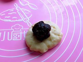 取一块面团，擀面杖擀成圆饼，加入豆沙馅。(豆沙馅的量可以根据个人喜欢添加）