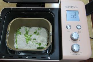 面包机桶提前清洗干净，擦干，装好搅拌叶。倒入全部面粉，盐，和菠菜汁。