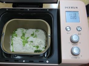 面包机桶提前清洗干净，擦干，装好搅拌叶。倒入全部面粉，盐，和菠菜汁。