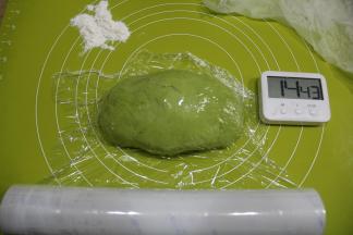 揉好取出面团，用双手手掌腕部力量用靠近身体位置向外揉搓，再收回，搓揉太长，就两边往中空折，略揉1分钟揉成均匀光滑的面团，盖保鲜膜醒十五分钟。