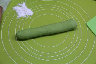 醒好，先切一半，其余继续用保鲜膜盖好。一半面团略搓长，然后双手放在面团上，上下来回搓长，滚动搓成均匀宽度的长条。