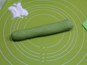 醒好，先切一半，其余继续用保鲜膜盖好。一半面团略搓长，然后双手放在面团上，上下来回搓长，滚动搓成均匀宽度的长条。