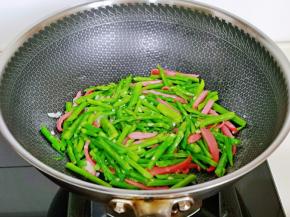加入焯水的芦笋快速翻炒。