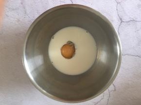 鸡蛋磕入盆中，加牛奶搅拌均匀。