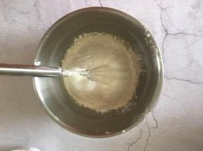 把面粉和泡打粉筛入鸡蛋液，翻拌至无干粉状态。