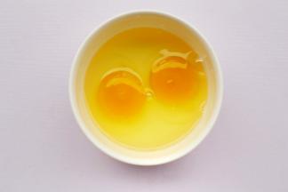 鸡蛋磕入碗中。