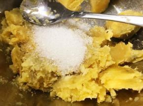 取出蒸好的红薯，趁热加入白糖后把红薯压成泥